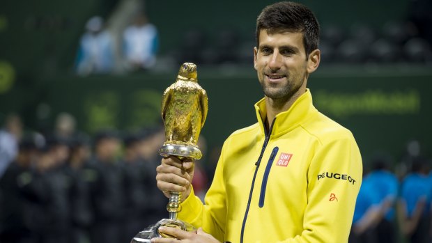 Glittering: Novak Djokovic holds the trophy after winning the men's final against Rafael Nadal at the Qatar Open.