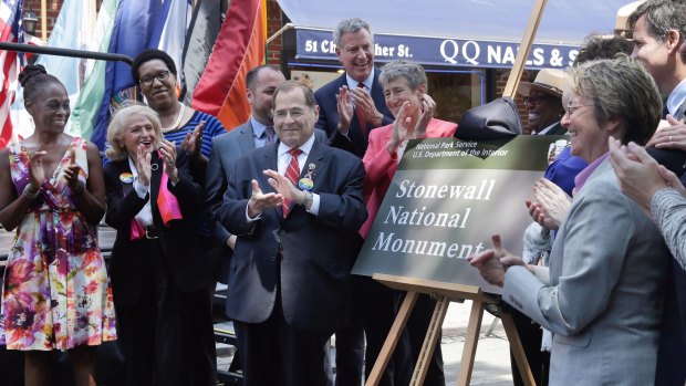 Unveiling a plaque during the dedication of the Stonewall National Monument, outside the Stonewall Inn, in New York's Greenwich Village.