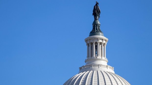 What is the name of the bronze statue that sits atop the US Capitol building's dome?