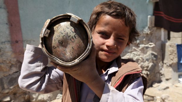 A boy near Sanaa holds a shell which landed from a nearby missile base after it was struck by a Saudi-led coalition air strike. 