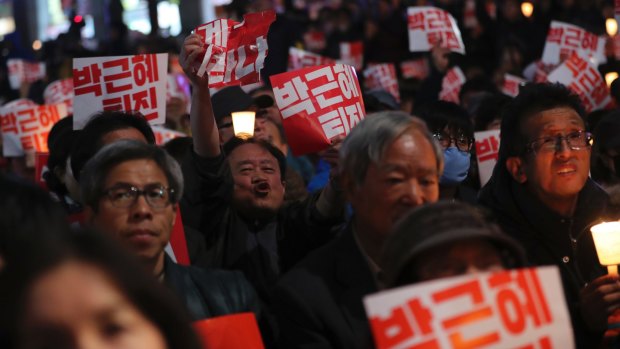Thousands of South Koreans hold signs during a rally calling for President Park Geun-hye to step down on Saturday.