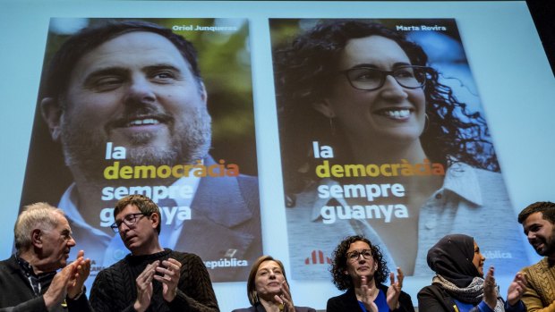 Posters showing Marta Rovira, third right and right on screen, and jailed former Catalan vice president Oriol Junqueras, left on screen, at a rally on Monday.