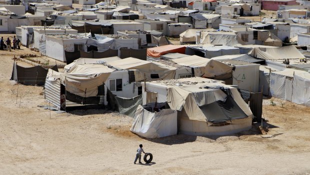 A Syrian refugee plays with a tyre at Zaatari Refugee Camp.