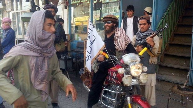 A Taliban fighter sits on his motorcycle adorned with a Taliban flag in a street in Kunduz, Afghanistan, in September. The Taliban takeover of the city gave a brief boost to an increasingly divided movement.