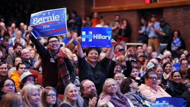 Bernie Sanders supporter Stephen Wong, left, and Hillary Clinton supporter Benita Lozano stand up for their candidates at the Democratic party caucus in Anchorage, Alaska.