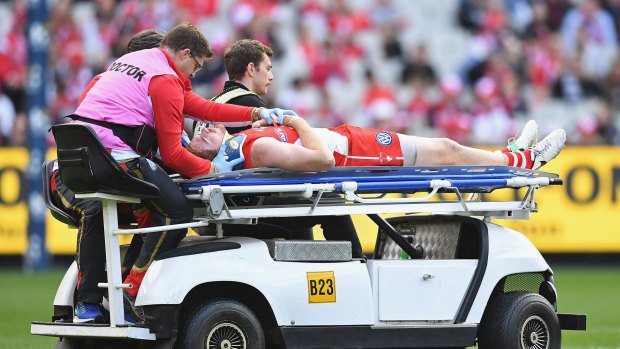 Gary Rohan of the Swans is taken off on a stretcher after being knocked out