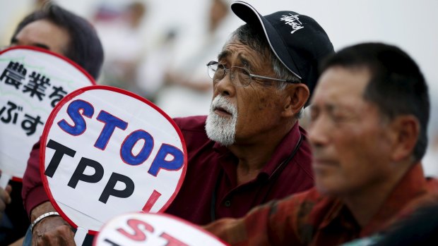 Japanese farmers hold placards opposing the Trans-Pacific Partnership in Tokyo.