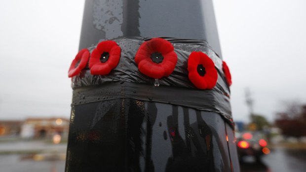 Poppies on a lamp post in front of the Service Canada building in the Quebec town of Saint-Jean-sur-Richelieu, where two soldiers were attacked, one of them fatally.