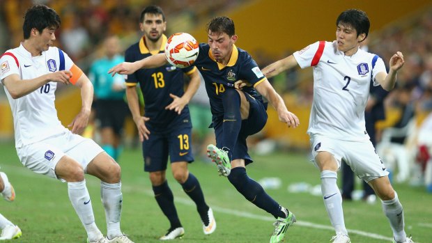 Surrounded: James Troisi of the Socceroos.