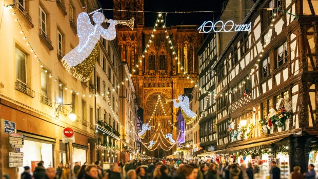 Tourists admire Christmas decorations on the iconic Rue Merciere.