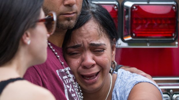 Friends and family grieve after a list of hospitalized victims was released, implying the death of those who weren't on the list and hadn't been heard from, outside a Hampton Inn & Suites hotel near the Orlando Regional Medical Center.