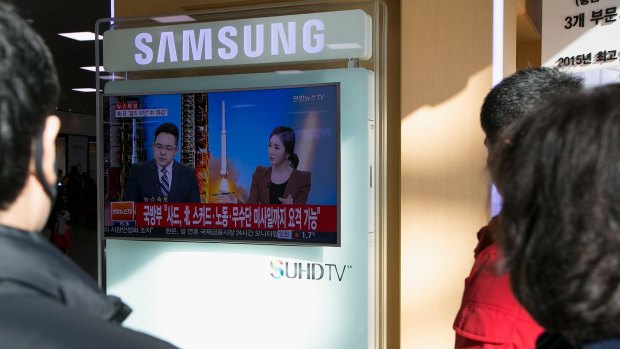 People in Seoul, South Korea watch news of North Korea's long-range rocket launch.