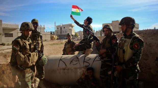 Kurdish Peshmerga fighters take a break in the besieged border town of Kobane. 