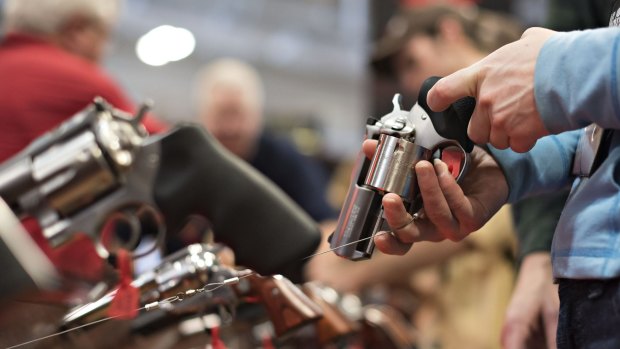 An attendee handles a revolver on the exhibition floor of the 144th NRA Annual Meetings and Exhibits in Nashville, Tennessee, in April.