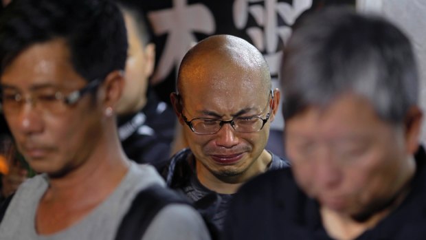 A protester cries as he mourns jailed Chinese Nobel Peace laureate Liu Xiaobo during a demonstration outside the Chinese liaison office in Hong Kong, on Thursday.