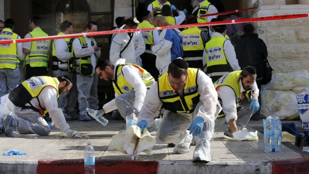 Members of the Israeli Zaka emergency response team clean blood from the scene of the attack at the Jerusalem synagogue.