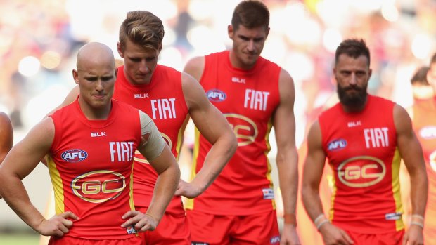 Heads bowed, Gary Ablett (left) and his Suns teammates leave the field after losing to Melbourne on Saturday. 