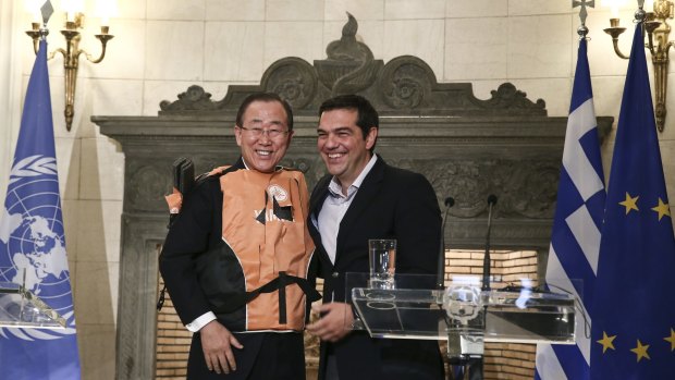 UN Secretary General Ban Ki-moon, left, wears a life jacket presented to him by Greek Prime Minister Alexis Tsipras in Athens.