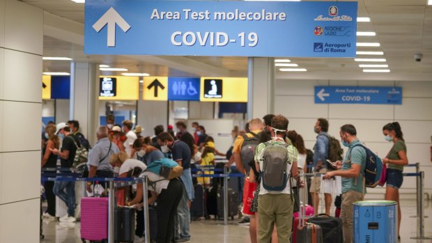 Vacationers arriving in Rome from four Mediterranean countries line up with their suitcases at Rome's Leonardo da Vinci airport to be tested.