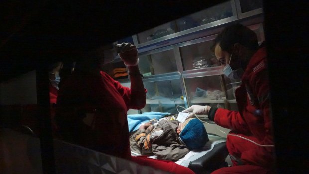 A severely ill child is evacuated by ambulance by Syrian Arab Red Crescent emergency workers.