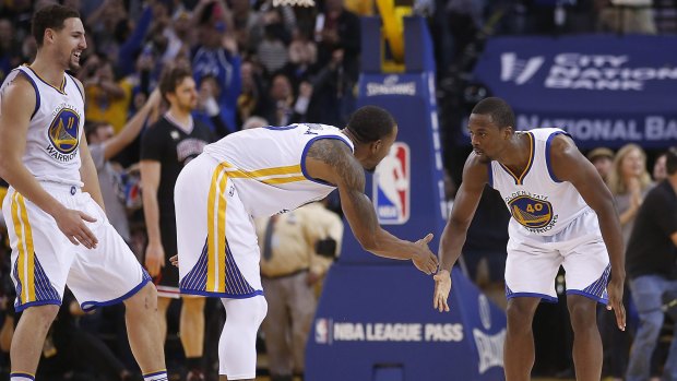 How do you do: Golden State Warriors forward Harrison Barnes celebrates with teammates Andre Iguodala and Klay Thompson. The Warriors won 106-94 over Chicago.