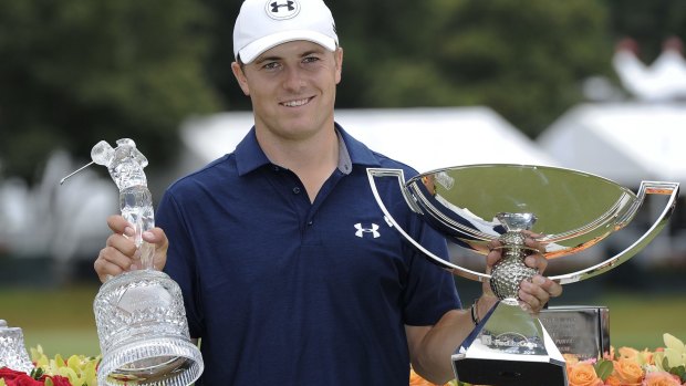 Jordan Spieth poses with the trophies after winning the Tour Championship golf tournament and the FedEx Cup at East Lake Golf Club in September 2015.