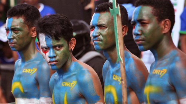 CNRT supporters  have their face and body painted with the party's colors during a campaign rally in Dili.