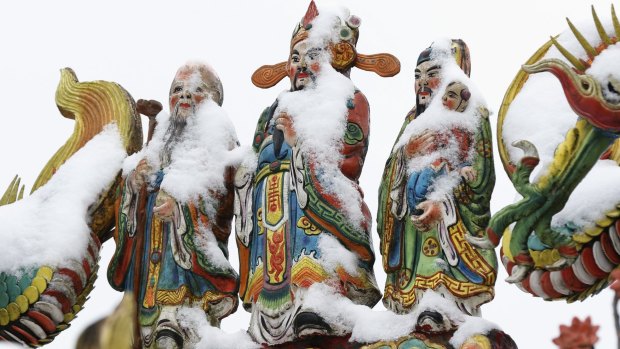 Snow sits on the Chinese god statues at the Pinglin temple in the high mountain area of New Taipei City, Taiwan, on Monday.