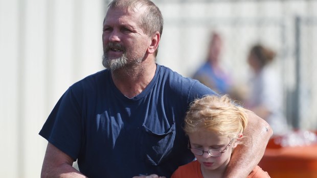 Joey Taylor walks with his daughter Josie after picking her up in Townville, following the shooting.