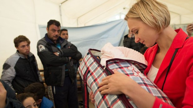 New born: Kolesnikova holds a baby at the Tabanovce refugee camp.