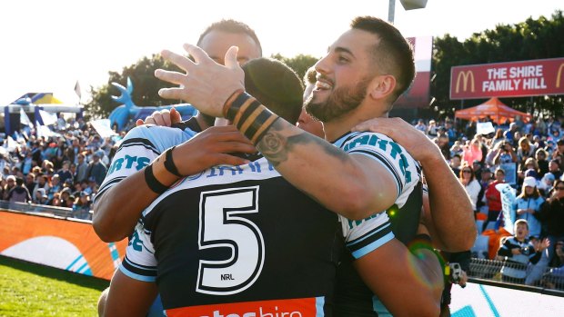 Shark frenzy: Jack Bird and Joseph Paulo congratulate Valentine Holmes after a try during the round 20 win over Knights.