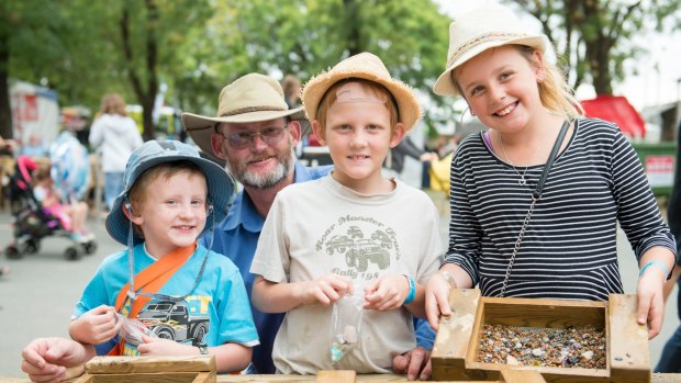 Paul, Isabelle , 9, Ronan 7, and Nicholas Davies 5 of Queanbeyan pan for gem stones at the Canberra Show. 