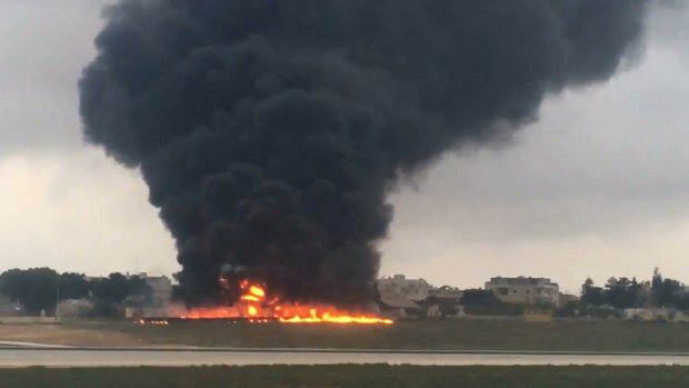 Smoke billows from a light plane that crashed after takeoff from Malta's main airport in Valletta.