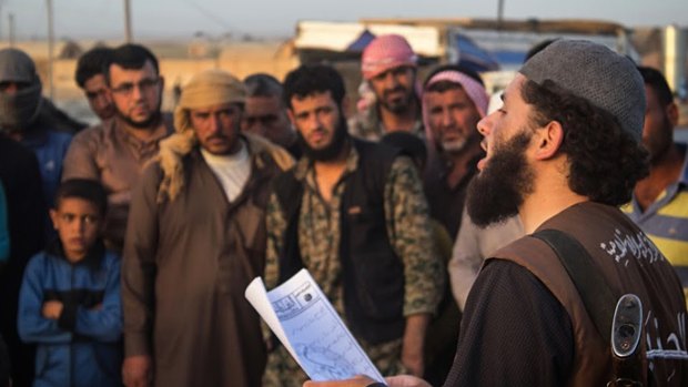 In this photo released in May 2015 by a militant website, a member of  Islamic State's vice police known as "Hisba", right, reads a verdict handed down by an Islamic court sentencing many they accused of adultery to lashing in Raqqa, Syria.