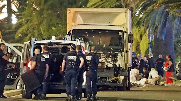 Police stand by as medical personnel attend a person on the ground on the Promenade des Anglais in Nice.