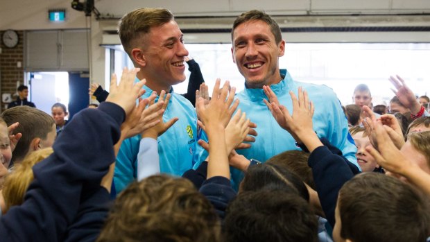 Kings of the kids: Socceroos Alex Gersbach and Mark Milligan with Double Bay Public School students on Wednesday.