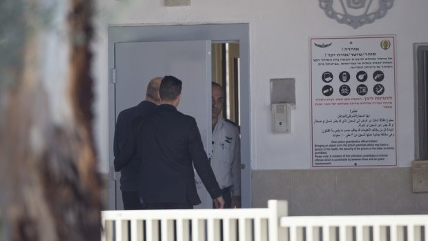 Ehud Olmert, left, enters prison to begin his sentence in the central Israeli town of Ramle.