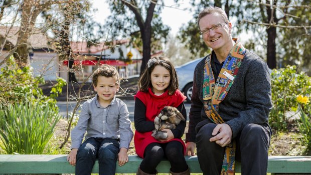 Siblings Cameron Harper 4, and Chloe Harper 7 with their rabbit Bambi, and minister of the Kippax Uniting Church, Gordon Ramsay, at  the animals service.