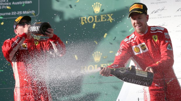 Ferrari driver Sebastian Vettel, right, of Germany sprays champagne.