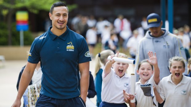 Brumbies and Vikings outside back Lausii Taliauli with excited year 5 students Emily Bermingham, Mailee King and Amelia Robinson at 
the Jerrabomberra Public School on Tuesday morning. 