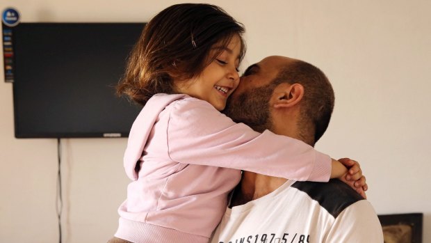 Syrian refugee Abdul Halim al-Attar kisses his daughter Reem, 4, at their house in Beirut.