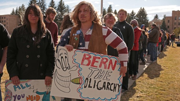 Attendees hold signs while waiting in line before a campaign event for Senator Bernie Sanders, an independent from Vermont.