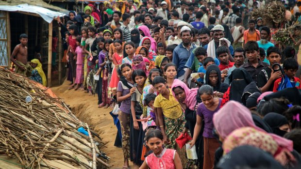 Rohingya Muslims wait in queues to receive aid at Kutupalong refugee camp in Ukhiya, Bangladesh.