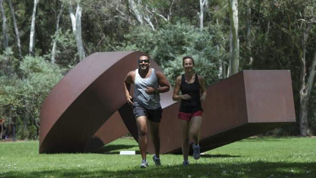 Lunchtime joggers, Link Perera of Kambah and Jodie Bijorac of Queanbeyan, run through the sculpture garden at the National Gallery of Australia. New figures show Canberra is the most active and cultured place in the country. 