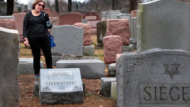 Sally Amon of Olivette, Missouri, reacts as she saw toppled gravestone of her grandmother Anna Ida Hutkin.