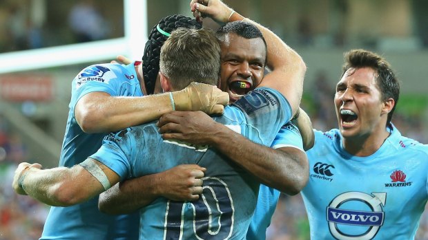 Kurtley Beale is congratulated by Waratahs teammates after scoring against the Rebels at AAMI Park on Friday.