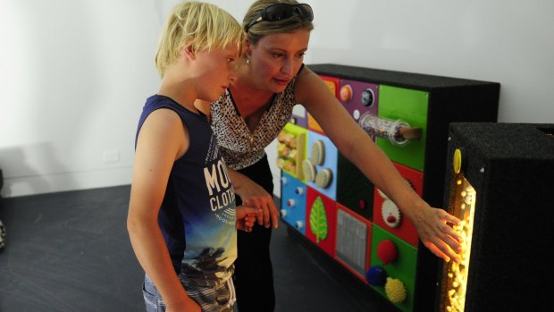 Kayne Lawton, 8, of Bruce, with his mother Beth in the sensory room at the Ricky Stuart House in Chifley.