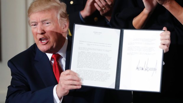 US President Donald Trump displays his presidential memorandum declaring the opioid crisis a public health emergency.