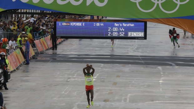 Moment of protest: Ethiopia's Feyisa Lilesa crosses his arms as he crosses the finish line.