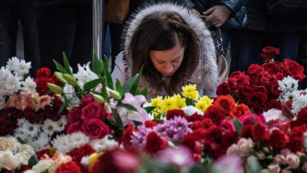 A woman at Pulkovo Airport in St Petersburg, Russia lights a candle in memory of the victims of the Airbus A321 crash.